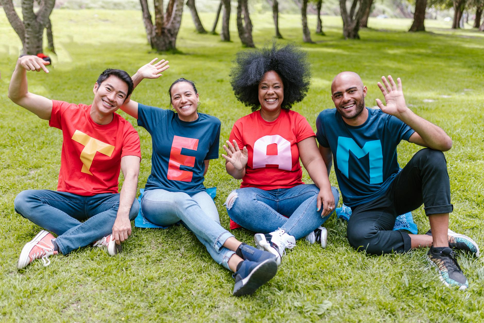 people sitting on green grass waving their hands