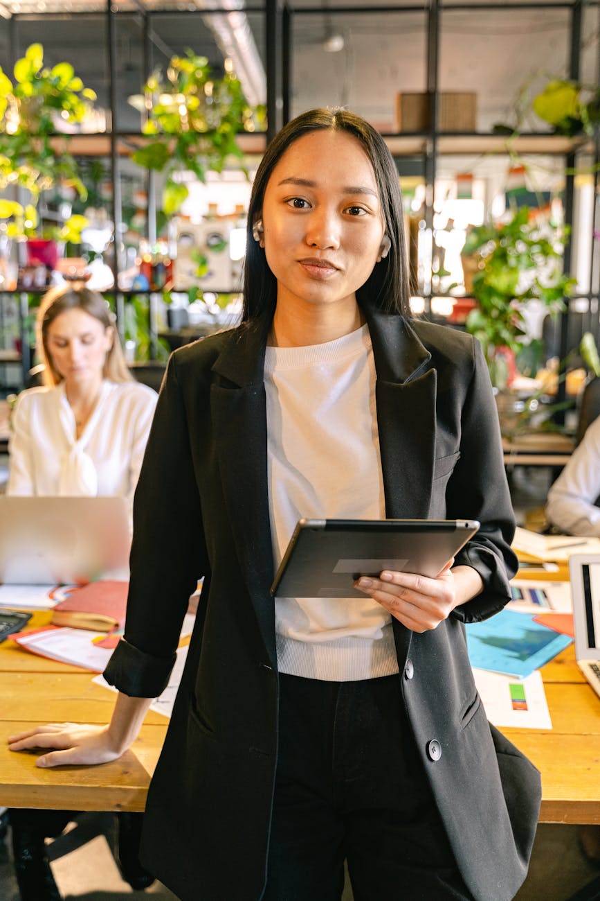 portrait of a woman wearing an office smart casual attire holding an ipad